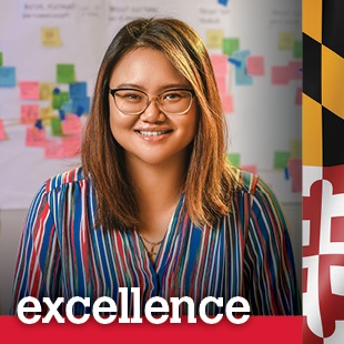 woman standing in front of a wall with sticky notes on it with the word excellence at the bottom