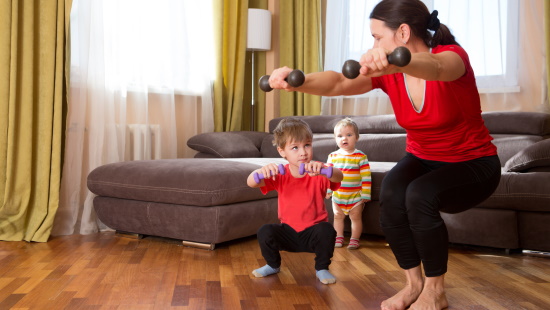 Mother exercising with two young children