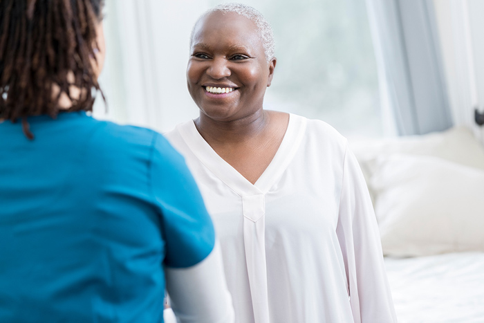 Provider standing with African American cancer patient