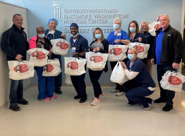 Ten UM BWMC team members holding bags with donated food