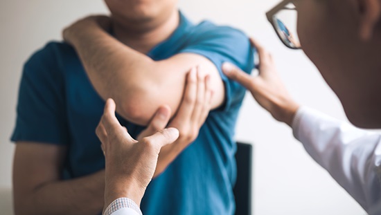 Physician examining patient's elbow