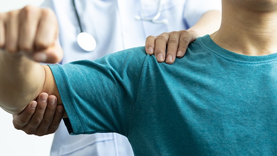 Physician examining patient's shoulder