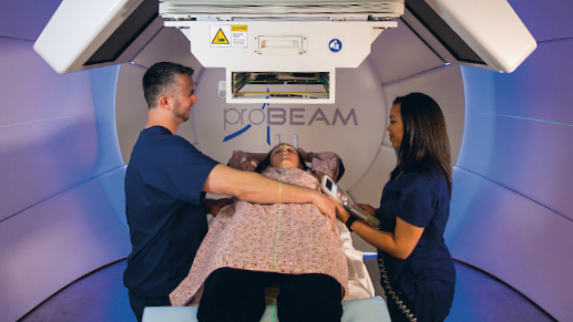 radiology imaging machine probeam with two clinicians and one patient being scanned