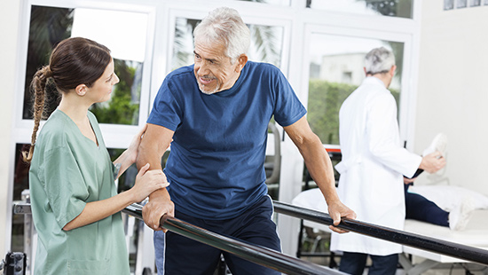 Patient walking with assistance and talking to physical therapist