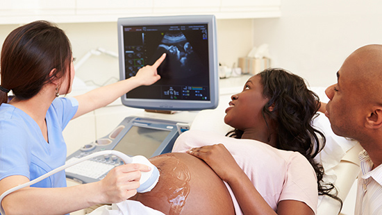 Maternal Fetal Medicine specialist showing ultrasound to pregnant woman