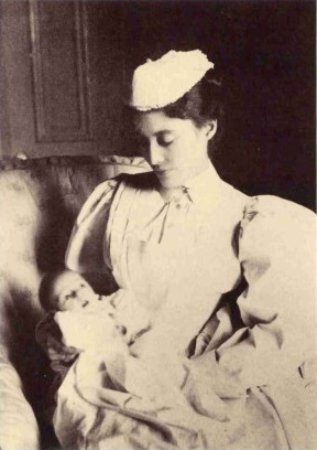 old black and white photo of a nurse holding a baby in 1873