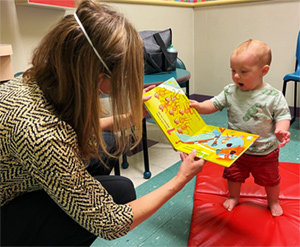 pediatricians giving a book to a very excited little patient