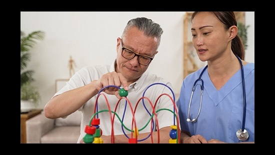 Patient concentration on bead movement device with a healthcare worker next to them