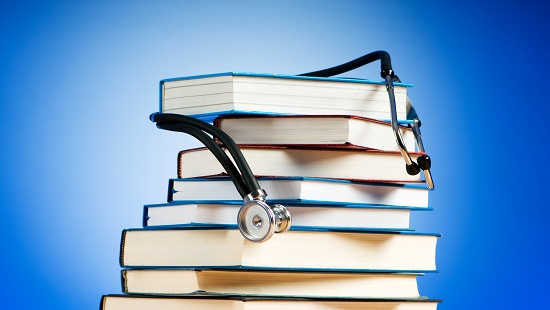 Stethoscope draped over stack of books