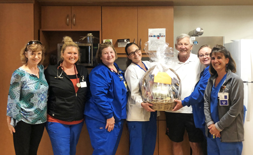 Gary Bolis stands with Chestertown nurses and thanks them for their care with a gift basket.
