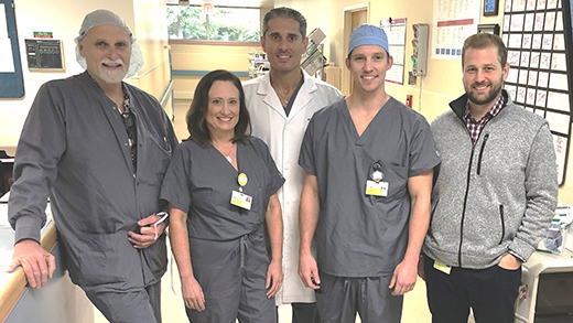 Five neurosurgery team members smiling 