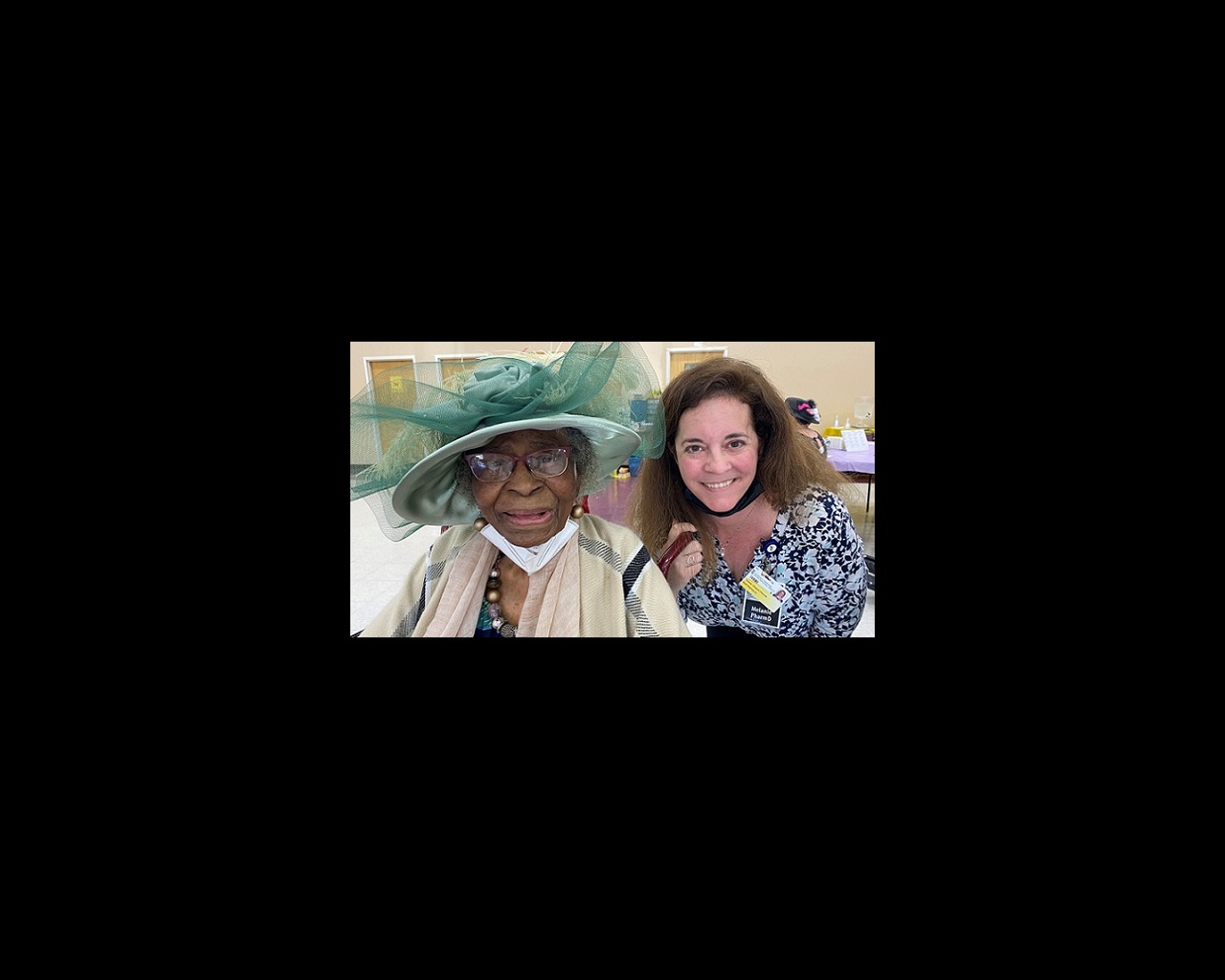 Two women smile for the camera. One is Beulah Jackson, in a green hat. The other is PharmD Melanie Chapple.