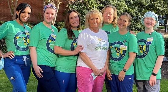 Seven women stand side by side wearing blue and green for the Living Legacy Foundation's Blue and Green Day 2022.