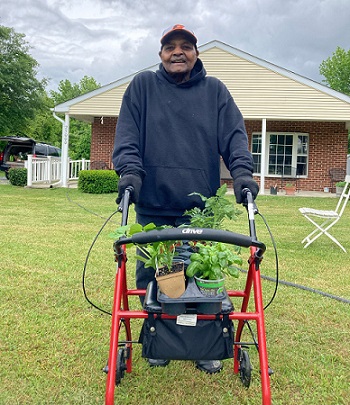 Joseph Boyer wheels up some plants for the garden at D’s Place in Worton. 