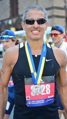 Dr. Khalid Kurtom smiles at the camera after finishing running the Boston Marathon.