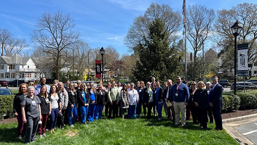 A large group of UM Shore Regional Health team members gathers on a bluebird day in the front circle of UM Shore Medical Center at Easton for the Donate Life flag-raising ceremony.