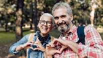Woman and man making heart shapes with their hands