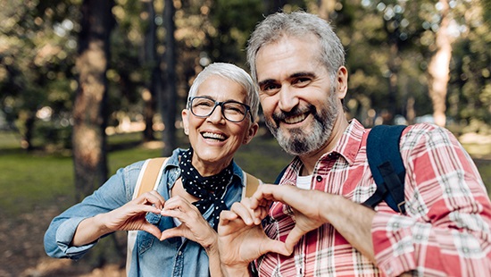 Woman and man making heart shapes with their hands