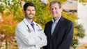 Doctor and man standing outside in fall 