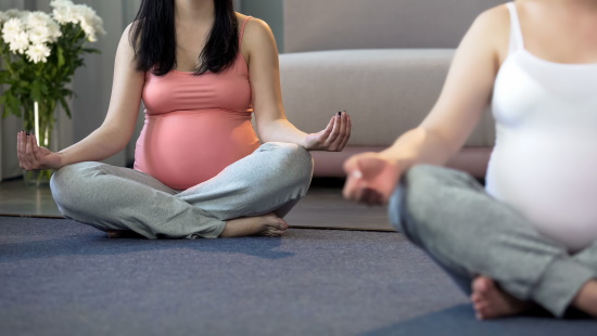 Two pregnant women practicing yoga