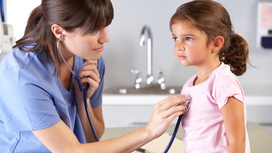 Pediatrician listening to girl's heart