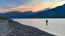 Person standing in water with mountain in the distance