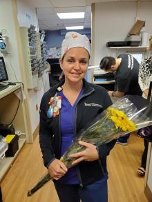 Kelly Lambert, RN Emergency Department, holding flowers