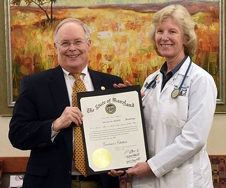 Sally B. Cheston, MD, right, receives an award for developing an oncology partnership with Johns Hopkins