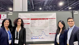 Two mean and two women standing on the side of a research poster