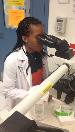 University of Maryland Infectious Diseases fellow looking through a microscope