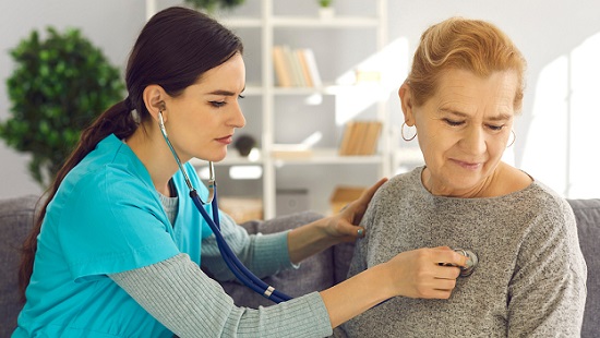 Health provider checking patient's heart rate with a stethoscope.