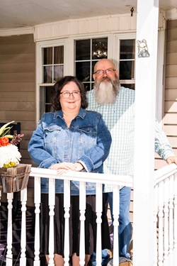 Nancy and Neil Olenick standing on front porch up close
