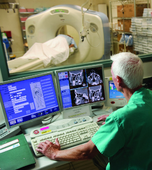 An imaging technician oversees a patient's MRI