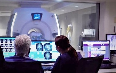 Two medical professionals looking at a screen showing images from an MRI-guided focused ultrasound.