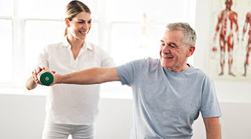 A photo of a physical therapist helping their patient with an exercise.