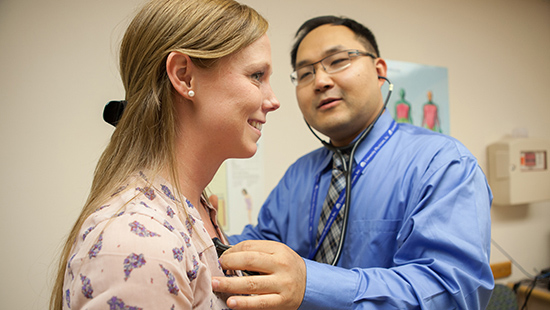 A physician listens to a patient's heart rate