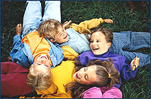Photo of children laying on the grass together