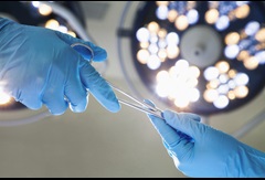 image of medical professional hands wearing gloves and passing scissors