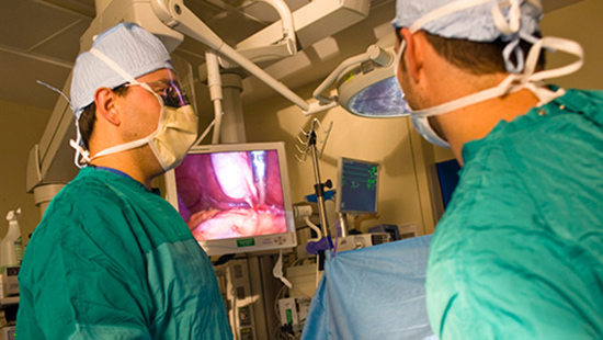 General surgeons looking at screen during surgery procedure