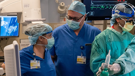 Three surgeons prepping a kidney for transplant