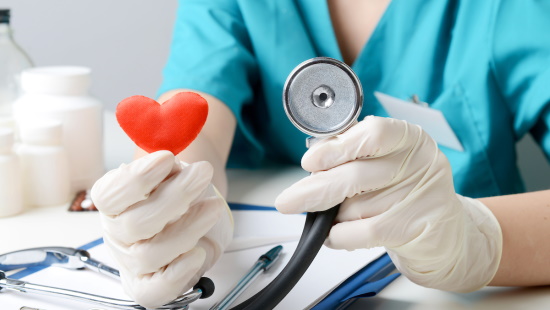 Woman holding a stethoscope and heart shaped figure