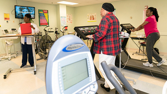 Nurse monitoring cardiac patients on treadmill