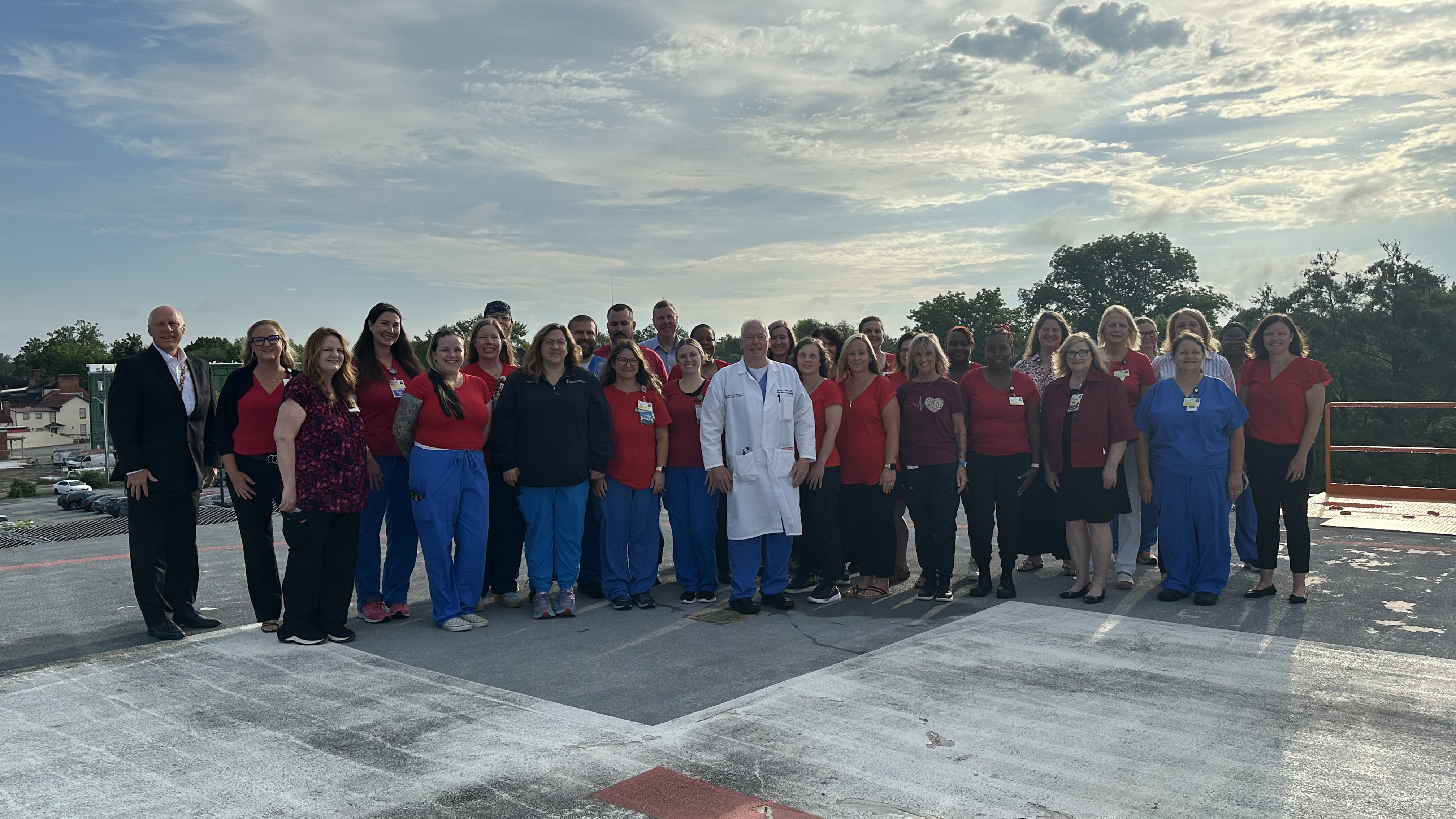 Dr. Jeffrey Etherton poses on the helipad at UM Shore Medical Center at Easton with his UM Shore Regional Health (UM SRH) colleagues from the Cardiac Catheterization Lab and UM Shore Medical Group – Cardiology, as well as UM SRH leadership team members.