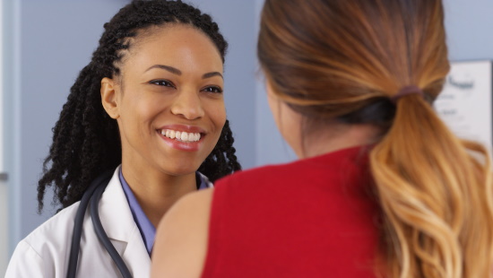 Female doctor speaking to woman in ponytail
