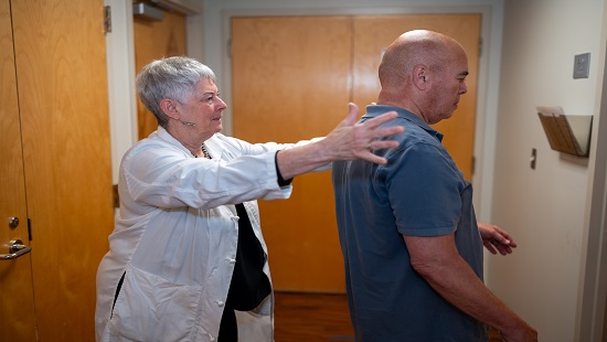 Neurology specialist helping movement disorder patient Neurology specialist helping movement disorder patient