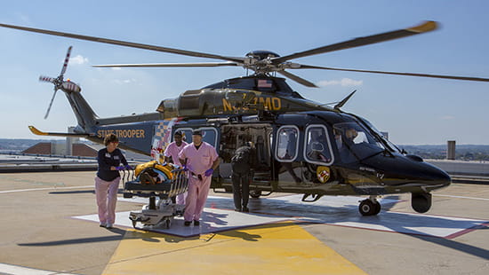 Health care providers wheel a patient from Shock Trauma helicopter